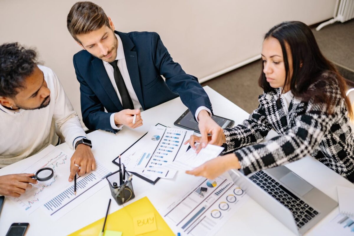 Business professionals engaging in a collaborative meeting with charts and documents.
